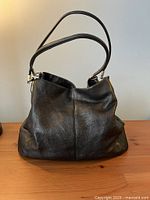 Front view of black pebbled leather hobo bag with dual straps