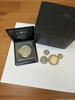 All four coins with presentation case visible