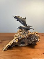 Front view of John Perry driftwood sculpture showing dolphins and base