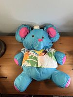 Front view of blue Puffalump elephant wearing tropical shirt