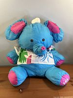 Front view of blue Puffalump Elephant plush seated on table