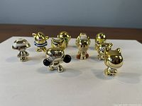 Front view of nine of the gold Crazy Bones figurines