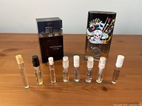 Group shot of two fragrance bottles and eight sample vials