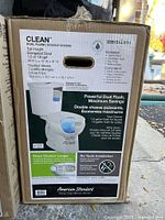 Front of boxed American Standard Clean toilet showing model and features