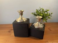 Both candlestick holders on display blocks