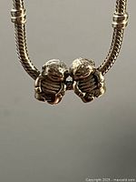 Front view of both Pandora boy charms on bracelet to show design and scale