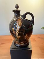 Front view of Kingsware flask with relief portrait and stopper