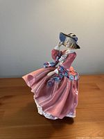 Front three-quarter view of figurine showing dress, hat, and face details