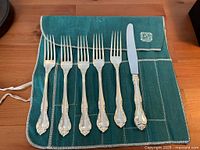 Overall view of five forks and knife on flatware roll