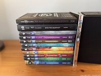 Stacked view of all eleven books plus card pack showing spines and numbering