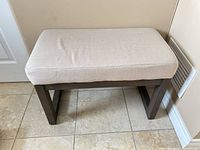 Top view of upholstered bench showing beige cushion and wooden frame