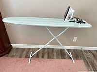 Full view of folded-out ironing board with iron on top
