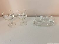 Full view of two wine glasses and creamer, sugar bowl, tray