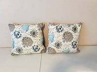 Front view of both square embroidered pillows