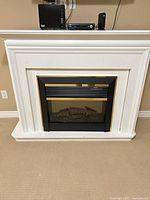 Front view of white mantel and electric fireplace insert
