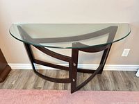 Front view of demi-lune console table showing glass top and curved wood frame