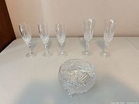 five cut crystal stemmed glasses and footed bowl on table