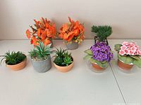 Seven artificial potted plants arranged on table