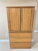 Front view of closed dresser showing oak veneer finish, double doors, three drawers