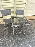 Full view of table and two chairs outdoors
