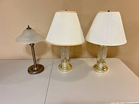 Front view of three lamps on table