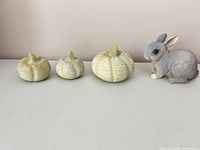 Three pumpkins and rabbit figurine lined up