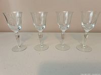 Front view of four etched cordial glasses showing design and shape