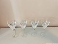 Four matching stemmed cut crystal glasses front view showing pattern and bases