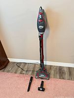 Full view of Shark Rocket Pro stick vacuum with attachments on floor
