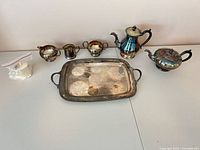 Full view of all seven silver-plated pieces on table