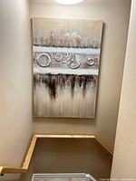 Full view of vertical abstract mixed-media canvas on stairwell wall