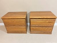 Front view of two identical golden oak nightstands