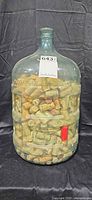 Full view of clear plastic 5-gallon jug packed with wine corks