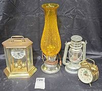Group shot of all four items: Bulova mantel clock, amber crackle hurricane lamp, Brooklyn Lantern, frog alarm clock