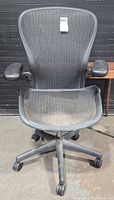Front view of Herman Miller Aeron chair showing mesh seat/back, armrests, base