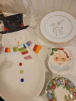 Group view of snowman platter, plates, Santa dish, fruit plate and glass tree