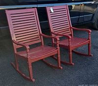 Front view of both red wooden rocking chairs side by side