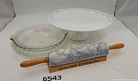Rolling pin on stand with two pie plates and milk glass cake stand