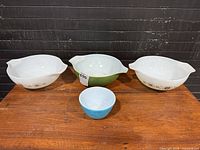 Four Pyrex mixing bowls arranged on table