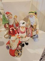 Group of four Santa figurines showing overall variety