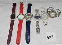 Six watches lined up showing straps, bracelets and faces