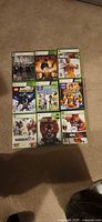All nine Xbox 360 game cases laid out on carpet