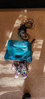 Top view of aqua blue translucent N64 console with controller and AV cable