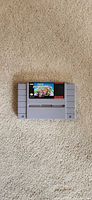 Front view of Super Mario Kart SNES cartridge on carpet