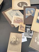Overview of assorted cabinet card photographs spread on table