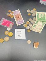 Overview of coins and three banknotes on table