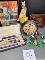 Front view showing pen set, figurine, clock, tin, matchbook frame and small items