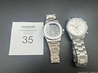 Two stainless steel men’s wristwatches side by side