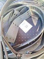 Group of grey/black tactical belts piled together