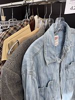 Rack showing denim Levi’s shirt, blazers, plaid garment